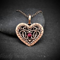 Small wire-wrapped ruby heart pendant Product detail:- This beautifully handcrafted small wire wrap heart pendant is made of copper wire and ruby bead. This pendant is oxidized for an antique look and polished to highlight the details of the wire work. This pendant comes with a copper chain in the length of your choice. The material used:- * Pure copper wire * Ruby bead Measurements:- Height- 3.5 cm Width- 3.1 cm Protection:- Copper will be tarnished after a while so try to limit contact with lo Handmade Rose Gold Heart Pendant Jewelry, Copper Heart Pendant For Jewelry Making, Handmade Copper Heart Necklaces, Handmade Copper Heart Pendant Jewelry, Unique Wire Wrapped Heart Pendant Jewelry, Handmade Copper Heart Pendant Necklace, Heart Shaped Wire Wrapped Pendant, Heart-shaped Wire Wrapped Necklace For Gift, Bohemian Wire Wrapped Heart Pendant Jewelry