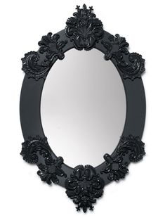 an ornate black mirror is shown against a white background with the reflection in it's center