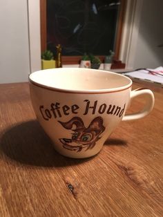 a coffee cup sitting on top of a wooden table