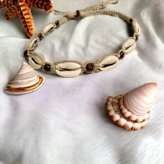 Embrace beachy vibes with our Natural Hemp Necklace, featuring authentic cowrie shells and earthy brown beads. This handcrafted piece captures a carefree, boho style that’s perfect for ocean lovers and free spirits. Made from eco-friendly hemp, this necklace is lightweight and comfortable, bringing a touch of natural beauty to any outfit. The cowrie shells add a coastal charm, while the brown beads lend a warm, grounding accent. Ideal for both casual and festival looks, this necklace makes a won Casual Brown Beaded Necklace For The Beach, Casual Brown Beaded Necklace For Beach, Adjustable Shell Necklace With Wooden Beads As Gift, Adjustable White Earthy Necklaces, White Adjustable Earthy Necklaces, Adjustable White Earthy Necklace, White Adjustable Earthy Necklace, Casual Brown Necklaces For The Beach, Casual Brown Necklace For Beach