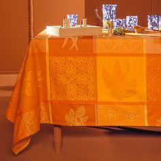 an orange table cloth with blue and white dishes on it