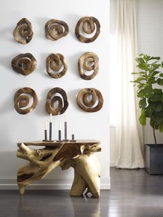 a wooden table with candles on it in front of a wall that has organic carved wood