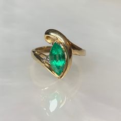 Vintage Emerald Ring, Emerald Diamond Ring, Pear Shaped Emerald Ring, Emerald Jewelry, Emerald Rings For Women, Gemstone Engagement Ring A whimsical vintage twirled solid gold ring featuring a colombian emerald weighing 1.37 carats accented by a single round diamond weighing 0.04 carats set in solid 14k yellow gold. *Ring size: US 6.5 *Complimentary resizing is available up to 3 sizes larger or smaller than stated size. Heirloom Marquise Emerald Ring In 14k Gold, Green Pear-shaped 14k Gold Rings, Heirloom Emerald Marquise Rings, Heirloom Emerald Ring Marquise Cut, Heirloom Green Marquise Cut Rings, Heirloom Ring With May Birthstone, Heirloom Marquise Cut Emerald Ring, Heirloom Ring With May Birthstone Center Stone, Heirloom Ring With Center Stone For May Birthstone