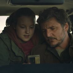 a man and woman sitting in the back seat of a car looking at each other