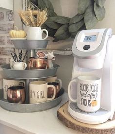 two coffee mugs are stacked on top of each other in front of a wreath