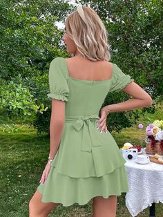 The ncocon green shift dress is perfect for any occasion, whether it's work or play! The lightweight woven poly fabric features a charming shift skirt, with a V-neckline and short flounce sleeves. The dress has a princess-seamed bodice, full button placket, and a tying waist sash for a flattering fit, and a flared skirt completes the look. Fabric name: polyesterPattern: solid colorTechnology: collage/splicingSkirt length: short skirtSkirt type: lotus leaf skirtCollar type: square collarSleeve ty Green Knee-length Dress For Brunch, Green Fitted Tiered Mini Dress, Fitted Green Tiered Mini Dress, Green Ruffled Mini Dress, Green Knee-length Solid Mini Dress, Green A-line Mini Dress For Spring, Green Square Neck Dress For Brunch, Casual Green Knee-length Mini Dress, Green Short Sleeve Dress For Brunch