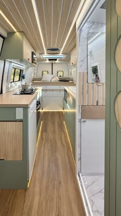 the interior of a bus with wood flooring and white walls, including an oven