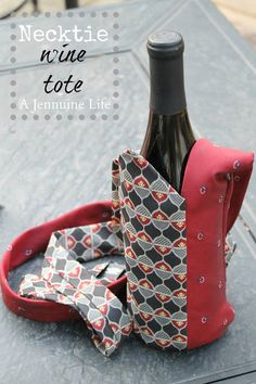 a bottle of wine sitting on top of a table with a bow tie around it