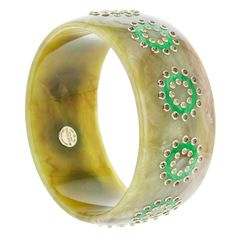 This Mark Davis Collector bangle was created from a richly marbled, soft green, vintage bakelite. Bright green rings of vintage bakelite have been carefully inlaid and are bordered by peridot on the inside and smoky quartz on the outside. All of the gemstones have been bezel-set in 18k yellow gold. This is a beautiful, seasonless piece. Metal 18-Karat Yellow Gold (Au750) Gemstones Peridot 1.60 ctwSmoky Quartz 3.60 ctw Dimensions Inner Diameter 65.00 mm (2.55 in)Inner Circumference 204.20 mm (8.0 Luxury Green Cuff Bracelet For Formal Occasions, Luxury Green Bangle, Green Luxury Bangle Jewelry, Luxury Green Bangle Bracelets, Luxury Green Cuff Bracelet As Gift, Elegant Green Round Bangle, Elegant Bakelite Bangle As Gift, Elegant Bakelite Bangle As A Gift, Elegant Bakelite Bracelet Jewelry