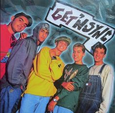 a group of young men standing next to each other in front of a street sign