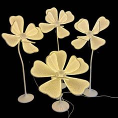 four white flower shaped lights on top of each other