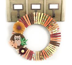 a wreath made out of strips of colored paper with an owl on it hanging from a light switch plate