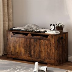 a wooden bench with drawers and pillows on it