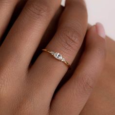 a woman's hand with a diamond ring on top of her finger and an engagement band