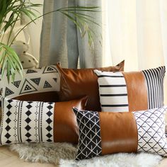 a bunch of pillows sitting on top of a wooden floor next to a potted plant