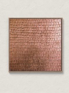 a square metal plaque mounted to the side of a wall with copper foil on it