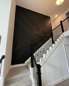 an empty staircase leading up to a black and white wall with metal railings on either side