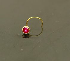 18 kt or 18 carat yellow gold handmade excellent single stone nose L band nose stud. Fabulous red color stone looking  pretty, excellent  bridesmaid , customized personalized jewelry from india.Metal-18 kt yellow gold.Item type-nose pin.Weight-0.060 grams.size-3.5 mm approx(top with stone)Closure- U band.Makes excellent gifting for birthday,mother's day. valentines day, Christmas day, wedding anniversary. Red Stone Jewelry, Cute Nose Piercings, Nose Pin, Baby Bracelet, Nose Jewelry, Nose Ring Stud, Single Stone, Nose Stud, Color Stone