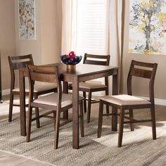 a dining room table and chairs with fruit on the plate in front of them,