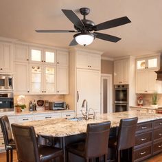 a kitchen with an island and ceiling fan