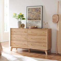 a wooden dresser sitting next to a white wall