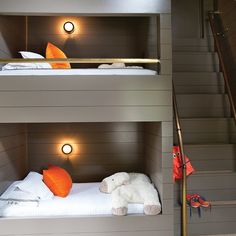 two bunk beds with lights on each side and a stuffed animal in the bottom bed