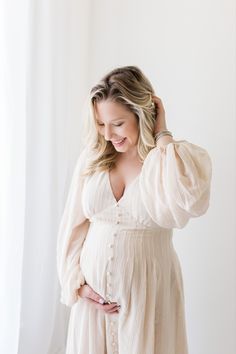 a pregnant woman wearing a white dress