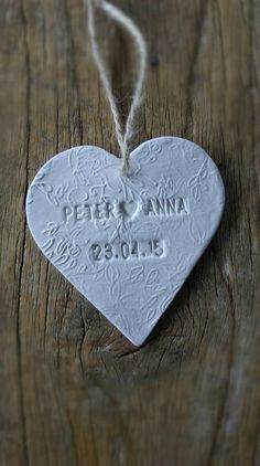 a heart shaped ceramic ornament with the name peter and ann written on it