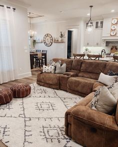 a living room filled with furniture and a large rug on top of a hard wood floor