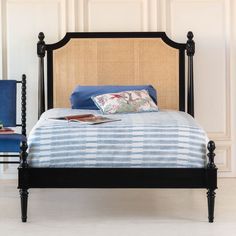 a black bed with blue sheets and pillows on it's headboard is shown