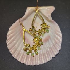 This gold floral teardrop earring is a picture of feminity with a hollow teardrop bordered with flowers as well as dangling beads.  The beads are a few different shades of green and the flowers are made up of glass.  The total dangle is 1.5 inches in length. Delicate Teardrop Hoop Earrings As Gift, Delicate Teardrop Hoop Earrings For Gift, Elegant Flower Shaped Teardrop Earrings, Elegant Flower Teardrop Earrings For Gift, Elegant Teardrop Earrings With Flower Charm, Bohemian Teardrop Earrings With Lever Back, Teardrop Earrings With Flower Charm, Teardrop Flower Pierced Earrings Gift, Teardrop Flower Earrings Gift