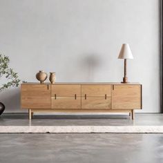 a living room scene with focus on the sideboard and vases in the foreground