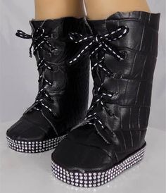 a pair of black boots with white polka dots on them