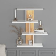 a white shelf with books and candles on it