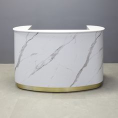 a white marble counter with gold trim around the top and bottom, against a gray background