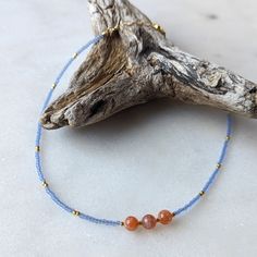 The pacific blue color of this necklace is one of my favorite trending colors. And when they are paired with Sunstone, the two colors pop in contrast. This coral and blue combination is perfect to give you all of the warm beachy vibes you could want! Sunstone is associated with the Sun's radiant energy. This is a stone that enhances your personal power and instills your life with joy, courage and optimism. This is a stone that you want close to you at all times. Colors: This beaded necklace feat Everyday Blue Bohemian Beaded Necklace, Everyday Bohemian Blue Beaded Necklace, Blue Gemstone Beads Jewelry For Beach, Blue Beaded Everyday Necklace, Blue Gemstone Necklace For Beach, Blue Gemstone Jewelry For The Beach, Minimalist Blue Jewelry For Beach, Adjustable Blue Ocean-inspired Necklace, Minimalist Blue Necklace For Beach