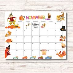 a november calendar with cartoon characters and pumpkins on it, sitting on a wooden surface