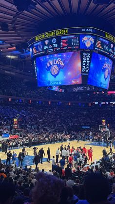 a basketball game is being played in an arena with many people standing on the court