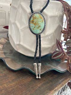 "This awesome bolo tie has a southwestern design and turquoise colored agate centerpiece. All stones are different. The cord is genuine black leather and it has silber metal detailing. Our bolos pair nicely with many of our belt buckles! They make wonderful gifts.    The western bolo tie rope length is 100cm(39\") ; charm agate stone pendant size is 5*4cm(1.97*1.57in)" Southwestern Bolo Tie With Sliding Knot, Western Style Lariat Jewelry For Gifts, Western Lariat Jewelry As Gift, Western Style Lariat Necklace For Gifts, Western Style Lariat Jewelry As Gift, Southwestern Lariat Turquoise Necklace, Southwestern Adjustable Lariat Turquoise Necklace, Adjustable Southwestern Turquoise Lariat Necklace, Southwestern Adjustable Turquoise Lariat Necklace