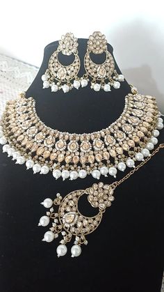 Beautiful Graceful Gold Color Reverse AD Necklace Set Chandbali Style Earrings Mang Tikka With White Pearl Drops Weddings Special Occasions Gold Color Kundan Polki Necklace/Kundan Polki Necklace Set / Matte Gold Choker Necklace/ Bridesmaid Jewelry Sets/ Flower Girl Necklace The latest Beautiful Traditional Reverse AD Necklace Set Beaded with Drop Clustered white beads is ideal for all occasions, gifting, etc. Please be advised of slight color variations due to the light effect. White Metal Jewelry Sets For Wedding, White Metal Bridal Necklace For Wedding, White Metal Jewelry For Weddings, Metal Chandbali Jewelry For Wedding, Metal Chandbali Wedding Jewelry, White Metal Jewelry Sets For Festivals, Metal Jewelry Sets For Weddings And Festivals, White Metal Wedding Jewelry, White Tilla Jewelry For Party