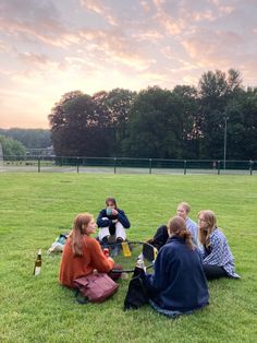 group of people sitting on the grass talking to each other