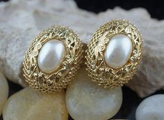 This is the perfect option for those who like cool, unique jewelry and the luxury, shine of gold and white. This earrings are well made, cute and/or elegant in design, and very desirable. The earrings are decorated with faux pearls. The earrings have filigree design. The clasp is in very good working condition. ♥ Age/era: Circa 1950s - 1960s. ♥ There is no hallmark. ♥ The earrings are about 1'' by 3/4''. Every one interested in the jewelry should remember that he or she must like their jewelry- Classic Gold Metal Pearl Earrings, Elegant Metal Clip-on Earrings For Anniversary, Elegant Oval Clip-on Earrings For Party, Gold Pearl Clip-on Earrings For Evening, Vintage Gold Pearl Earrings For Gift, Vintage Gold Pearl Earrings As Gift, Vintage Gold Jewelry With Elegant Design, Gold Pierced Pearl Earrings For Party, Gold Ornate Clip-on Earrings