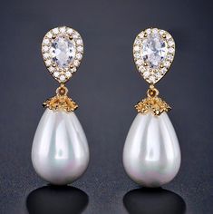 A classy and delicate pair of earrings perfect for the romantic bride, featuring pearls in an iridescent white color and clear cubic zirconia. Electroplated with noble metals (rhodium, 14K rose gold, and 14K yellow gold) for a flawless finish which perfectly enhances the intricate detailing and conveys a modern take on old elegance, these exquisite earrings will add a touch of sophistication to any wedding gown or formal ensemble. Length: 1.25" (approx. 3.2cm); Width: 0.4" (approx. 1cm); Weight: Party Pearl Earrings With Cubic Zirconia, Elegant Bridal Earrings In Diamond White Cubic Zirconia, White Cubic Zirconia Crystal Earrings With Elegant Design, Elegant White Pearl Embellished Earrings, Pearl White Pear-shaped Party Jewelry, Anniversary Pearl Bridal Earrings With Diamond Accents, Glamorous White Bridal Earrings With Diamond Accents, Pearl Drop Cubic Zirconia Earrings For Party, Teardrop Pearl Earrings With Cubic Zirconia For Party