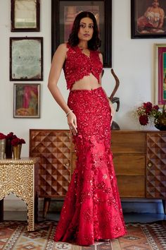 This structured red mermaid lehenga set personifies the emblem of romantic glamour. The set features intricate embroidery of cutdana work and dori with red sequins, beads, and floral applique work adorning both the skirt and blouse. Its focal point is the tassel detailing flowing at the bottom of the skirt with cute flower motifs made of sequins. • Sleeveless blouse with floral applique detailing highlighted with nalki crystals and beads.• Blouse contains a metal hook on the front side.• Heavily embroidered dupatta with botanical motifs detailing accentuated with sparkling sequins and crystals. • Lehenga skirt adorned with floral applique handwork detailing and drop-down tassels adorning the bottom of the skirt. • Lehenga contains a left zipper for support along with a metal hook.From Mole Red Sleeveless Lehenga For Party, Sleeveless Red Lehenga For Party, Red Sleeveless Party Lehenga, Red Floor-length Sets For Reception, Red Floor-length Choli With Sequins, Elegant Red Lehenga With Sequins, Red Sequined Floor-length Choli, Red Sharara With Mirror Work For Party, Red Embellished Party Wear Set