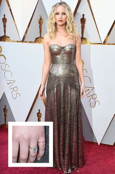 an image of a woman in a gold dress and diamond ring on the red carpet