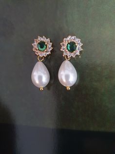 Amazing and OOAK Emerald green earrings, leave stunning impression on everyone! Very classic and has a glamour that can be achieved only with this white pearl and green stone crystals combination: beautiful Swarovski white drop pearls and green Emerald surrounded with tiny crystal Swarovski rhinestones.    I have a matching necklace: https://www.etsy.com/il-en/listing/90528659/bridal-necklace-genuine-emerald-stone?click_key=e18de233524584b28d69e078e8931ba7e38d1eef%3A90528659&click_sum=32f349a7&ref=shop_home_active_9&sts=1 A gorgeous shiny drop pearls earrings features Elegance and style: A beautiful pair made of golden filigree set with Swarovski rhinestone and vintage style pearls, tiny clear crystals and teardrop pearls that has such an impressive style. The back of the earring is ear pi Crystals Combination, Delicate Bridal Earrings, Emerald Green Earrings, Earrings Emerald, Ivory Earrings, Pearls Earrings, White Pearl Earring, Rhinestone Wedding, Ivory Pearl