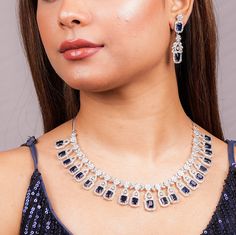 Sapphire Diamond Necklace Set features a stunning blue stone centerpiece surrounded by sparkling CZ American diamonds. The set includes a matching ring, making it a perfect statement piece for a contemporary Indian bride. Ideal as a wedding gift, it exudes elegance and modern sophistication. *𝐏𝐑𝐎𝐃𝐔𝐂𝐓 𝐃𝐄𝐓𝐀𝐈𝐋* * 𝐌𝐚𝐭𝐞𝐫𝐢𝐚𝐥: Brass * 𝐏𝐥𝐚𝐭𝐢𝐧𝐠: White Rhodium Plated * 𝐒𝐭𝐨𝐧𝐞: AAA-quality CZ Diamond & Sapphire. *𝐃𝐈𝐌𝐄𝐍𝐒𝐈𝐎𝐍𝐒* *𝐍𝐞𝐜𝐤𝐥𝐚𝐜𝐞* * 𝐖𝐞𝐢𝐠𝐡𝐭: 56 gm  * 𝐃𝐫𝐨𝐩  𝐋𝐞𝐧𝐠𝐭𝐡: 4.7 Inches * 𝐋𝐞𝐧𝐠𝐭𝐡: 9 Inches * 𝐖𝐢𝐝𝐭𝐡:  1.1 Inches *𝐄𝐚𝐫𝐫𝐢𝐧𝐠𝐬* * 𝐖𝐞𝐢𝐠𝐡𝐭: 8 gm each * 𝐋𝐞𝐧𝐠𝐭𝐡: 1.85 Inches * 𝐖𝐢𝐝𝐭𝐡:  0.55 Inches * 𝐂𝐥𝐨𝐬𝐮𝐫𝐞: Push Back 𝐕𝐢𝐬𝐢𝐭 𝐎𝐮𝐫 𝐅𝐀𝐐𝐬 𝐟𝐨𝐫 𝐒𝐡𝐢𝐩𝐩𝐢𝐧𝐠 𝐏𝐨𝐥𝐢𝐜𝐢𝐞𝐬 𝐚𝐧𝐝 𝐂𝐚𝐫? Sapphire Diamond Necklace, Blue Statement Necklace, Bridal Necklace Set, Manish Malhotra, Diamond Necklace Set, Cubic Zirconia Necklace, Pakistani Jewelry, Cz Jewelry, Matching Rings