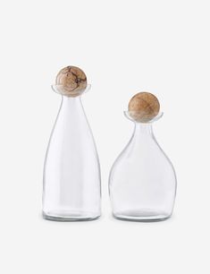 two glass bottles with corks on the top