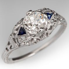 an antique diamond and blue sapphire ring with filigrees on the sides, set in white gold