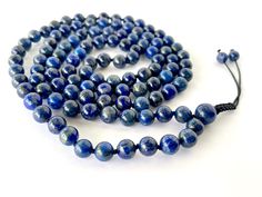 "Handmade in Rochester Hills - Michigan, using only high quality natural 8MM Lapis Lazuli gemstones that are sourced ethically (and we put extra effort to keep it that way ). WATERPROOF, ADJUSTABLE and  KNOTTED between each bead.  We ship within 1-2 business days. * Gemstone: Lapis Lazuli * Bead size: 8 mm * Circumference Length: 39 inches + 2 inches adjustable * Number of gemstones: 108 beads + 1 guru bead * Knotted * Wear this Mala as a bracelet or as a necklace. Gemstone description card included. Mantra card included, Gift box included.  ♥ Lapis Lazuli reminds us of the power of the spoken word and is one of the best stones to use when opening and balancing the Throat Chakra. Lapis Lazuli helps to foster full verbal expression, and clears problems caused by \"swallowing your tongue\". Rochester Hills Michigan, Beads Mala, Mala Meditation, Buddhist Prayer, Lapis Lazuli Beads, 108 Mala Beads, 108 Bead, Mala Bracelet, Silk Cord